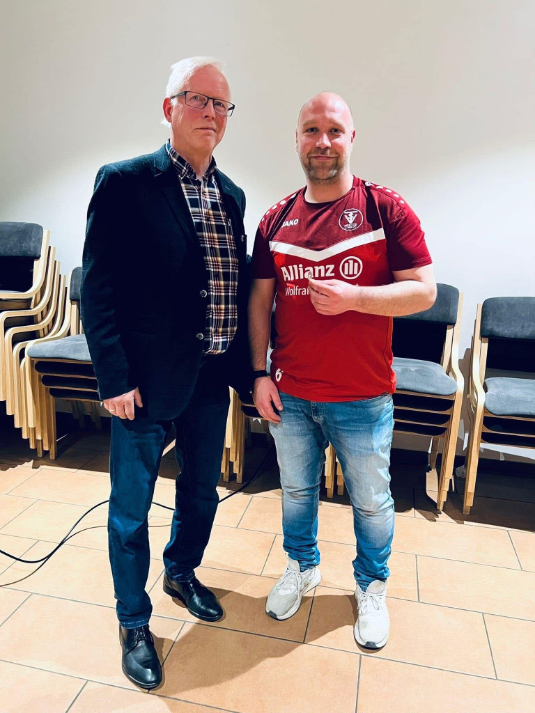 Zwei Männer bei der Jahreshauptversammlung 2026, einer im Trikot des TuS Neetze